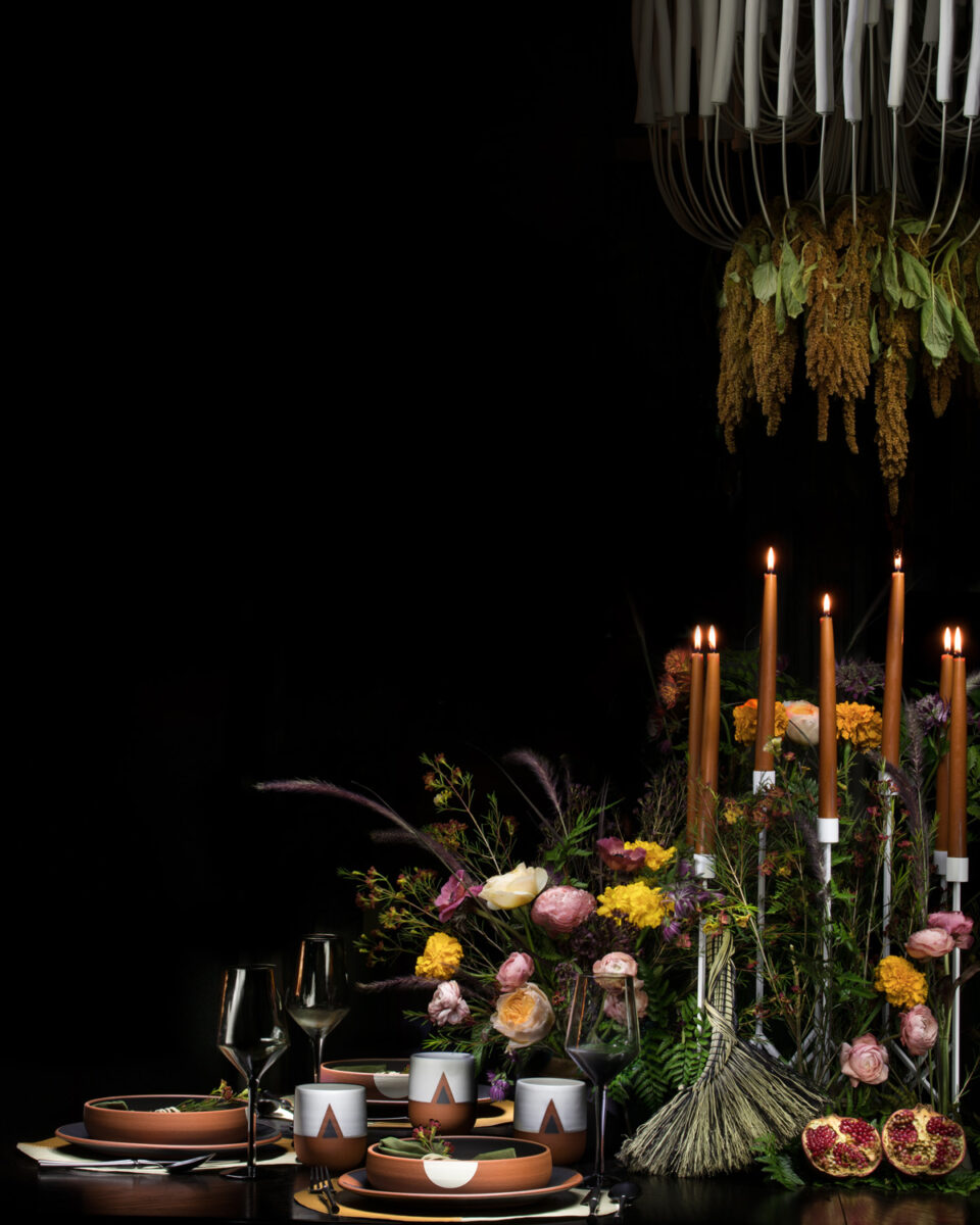A fall table setting with ceramics, flowers and candles.