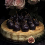 Close up of figs on cheesecake with roses above.