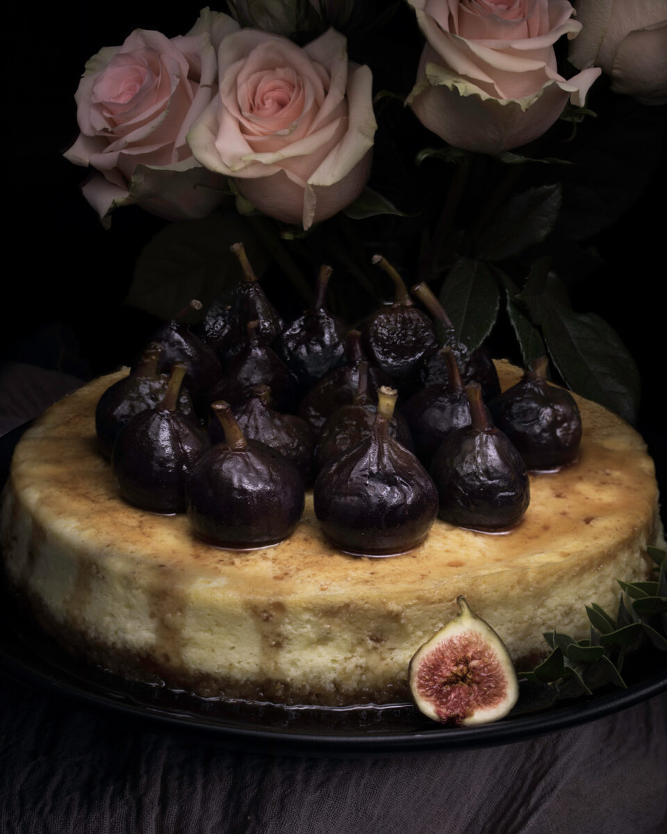 Close up of figs on cheesecake with roses above.